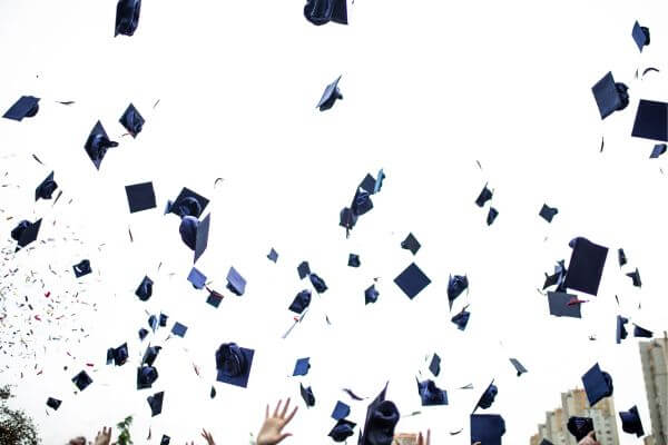 Picture of graduation hats being thrown into the air for typical graduation gifts from parents.