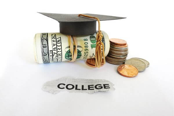 Picture of rolled hundred bills with a graduation cap on it for how to pay for college without parents help.