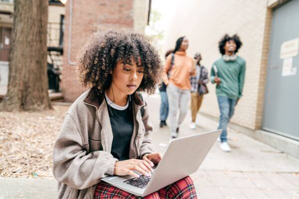 A person looking on a computer to se how can I pay for college by myself.