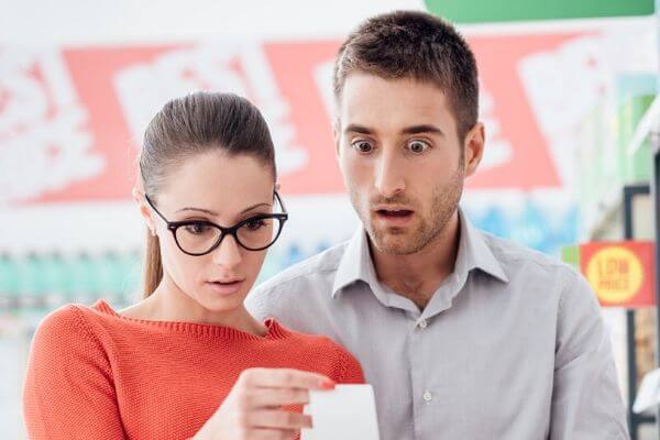 Picture of couple checking a receipt which is a frugal life hack