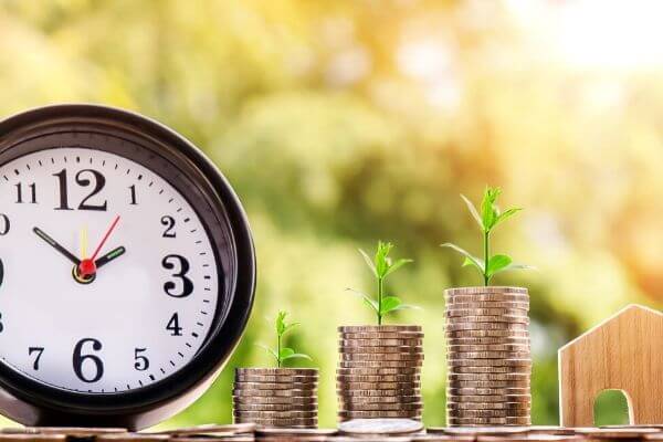 Image of a clock and coins to see can you live on $30000 per year.