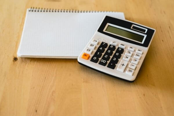 Picture of a notebook and calculator to figure out simple Ways To Increase Your Hourly Wage of $24 per hour