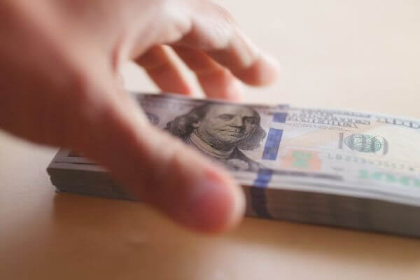 Picture of a hand grabbing cash to show how to spend money to make money.