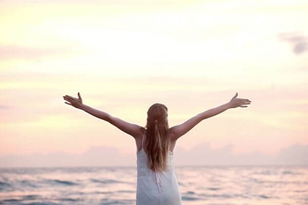 Picture of a lady at the beach figuring out living life with intention and purpose.