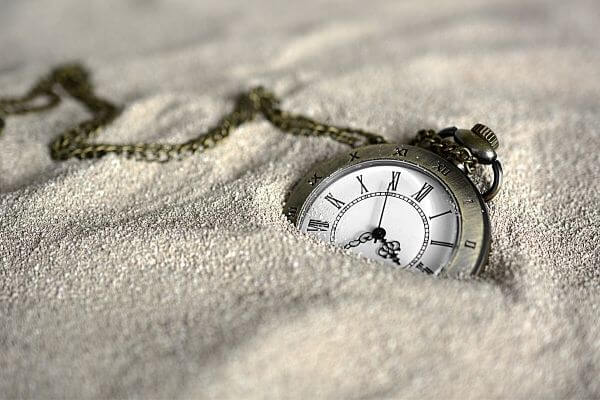 Picture of a clock in sand to represent 30 day financial challenge