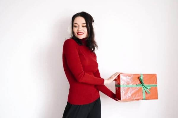 Picture of a lady holding a Christmas present.