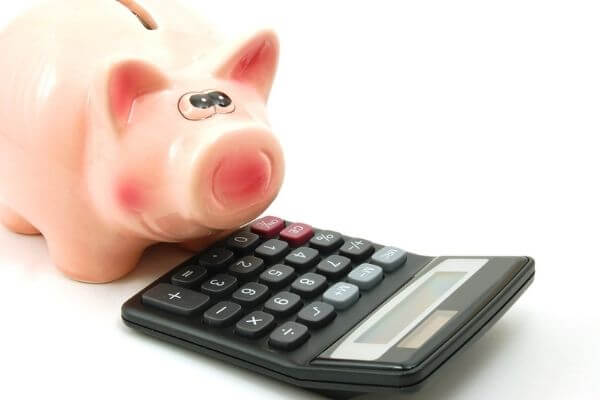 Picture of a calculator and saving pig to show the benefits of being frugal and thrifty.