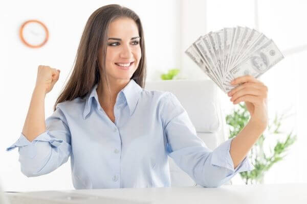 Picture of a lady pumping her fist with lots of hundred dollar bills for powerful money affirmations.