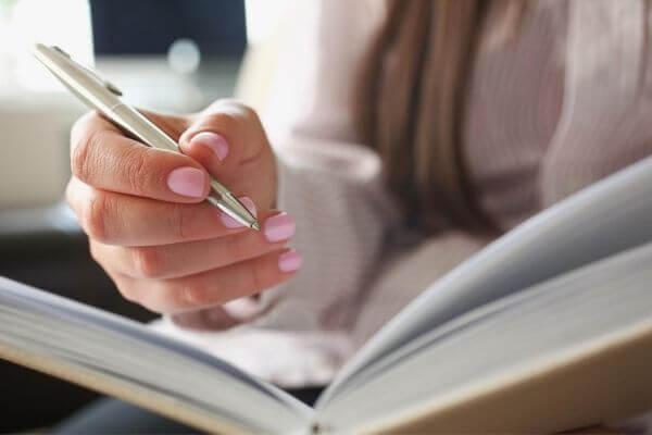 Picture of someone writing in a journal the skills needed to be successful.