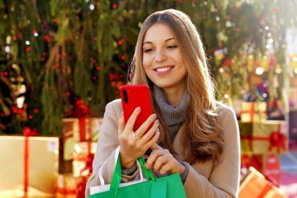 Picture of a lady scrolling on her phone wondering what do i want for christmas