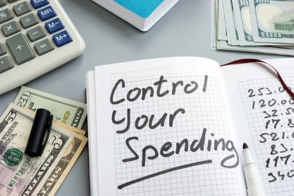 Picture of a journal with the words - control your spending - for why budget by paycheck.