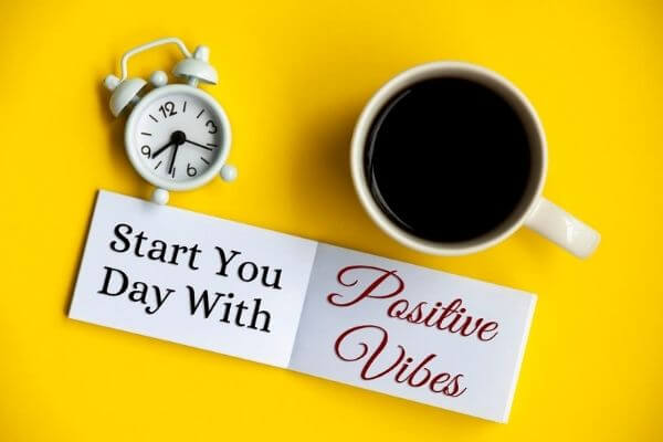 Picture of a clock, coffee, and a sign that says start your day with positive vibes for how early is an early morning shift.