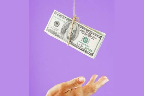 Picture of hundred dollar bills hanging from a rope for which real estate career makes the most money.