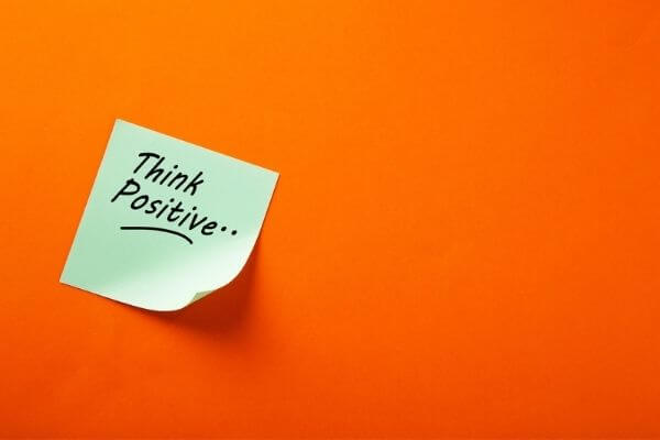 Picture of a sticky note with the words think positive for growth mindset examples.