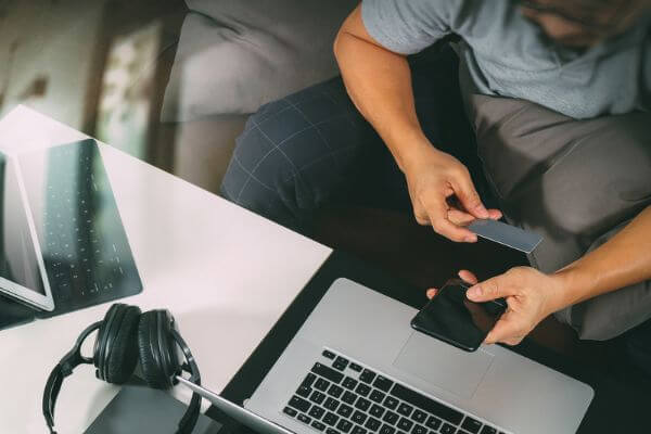 Picture of someone on a computer and phone.