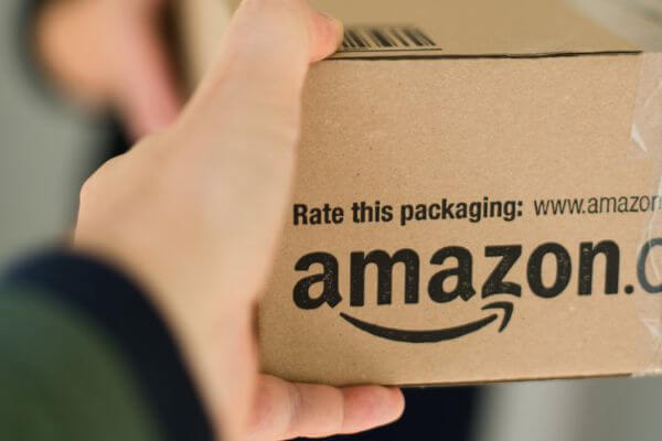 Picture of an Amazon box being handed to a customer for how do I track my amazon delivery.