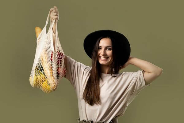 Picture of a lady with a reusable grocery bag.