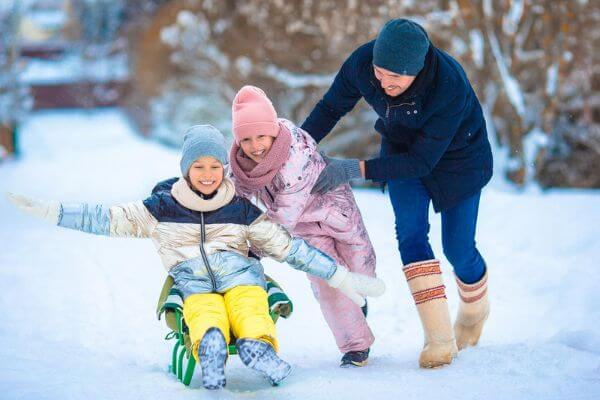 Picture of a family having fun in the winter for ideas for no gift Christmas activities