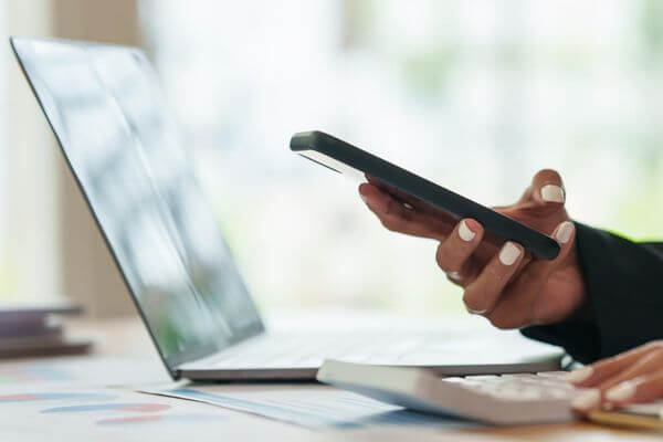 Picture of calculator and phone for How Much Is $14 Per hour per Year?