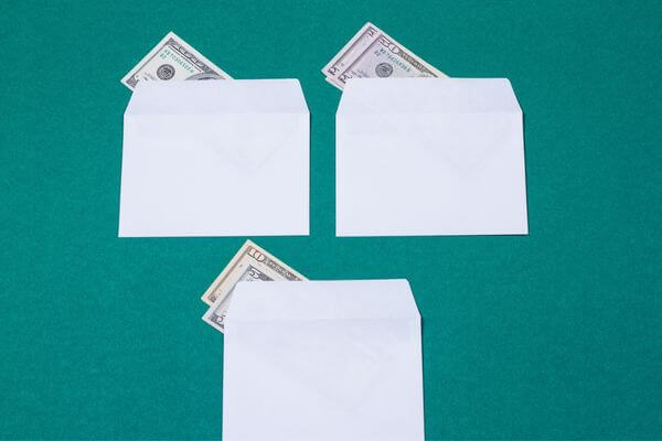 image of white envelopes with cash for the 100 envelope challenge printable