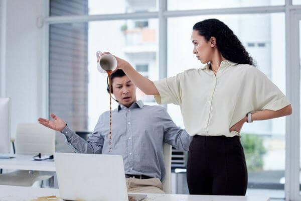 Picture of a lady pouring coffee on a laptop for I hate my job.