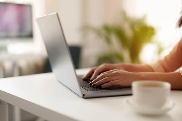 Picture of someone typing on a laptop looking for a gift card exchange kiosk near me.