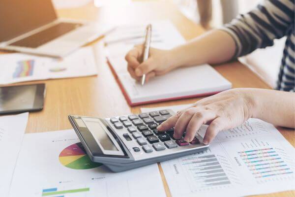 Picture of a calculator and paper to figure out 51k salary hourly calculator.