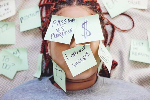 Picture of a lady covered in sticky notes for taking action to manifest and create your dream board.