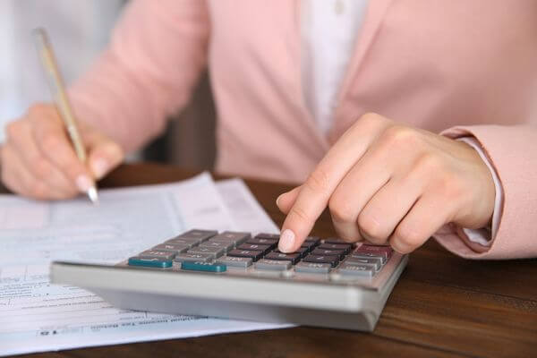 Picture of a calculator and money for $75 an hour salary calculator.