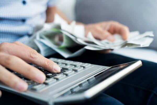 Picture of a calculator and money for the 39 an hour salary calculator. 