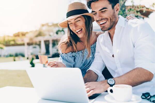 Image of a computer and card in someone's hand to see can you live on $72000 per year.