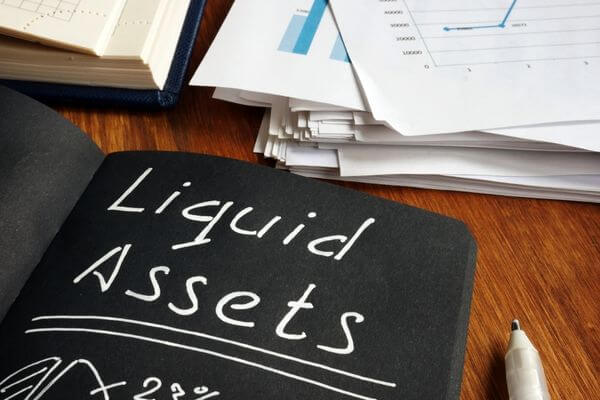 Picture of a notebook with the words liquid assets to represent different assets and a dollar amount beside each one