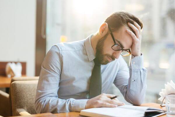 Picture of a guy trying to figure out how to explain the absence due to a family emergency excuse.