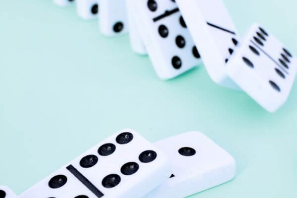 Picture of dominoes falling for possible consequences associated with good family emergency excuses.