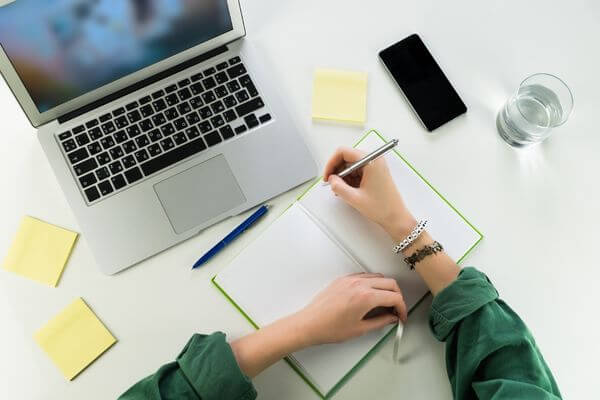 Picture of laptop and notebook for online summer jobs for teachers.