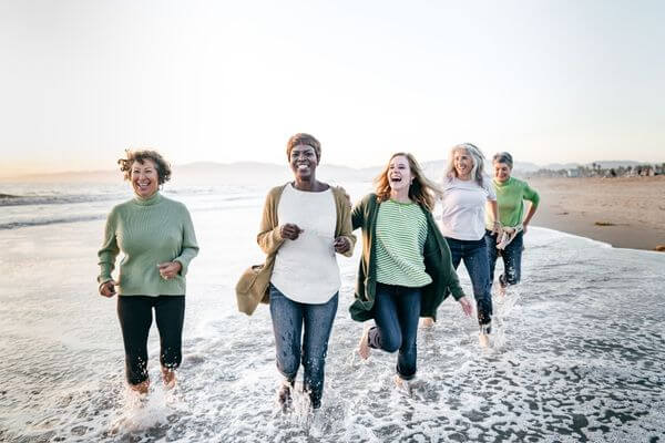 Picture of ladies running free along a beach.