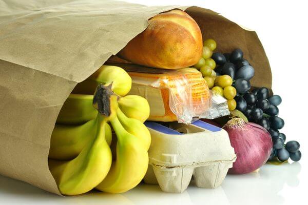 Picture of a grocery bag filled with budget friendly healthy foods.