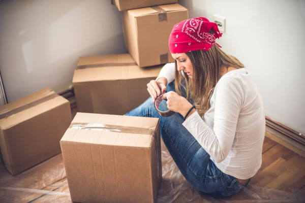 Picture of a lady packing moving boxes for tips for living on your own as a young adult