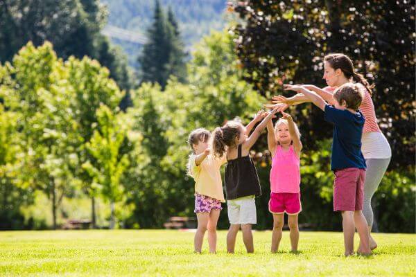 Picture of a teacher starting a nanny agency with kids around them.