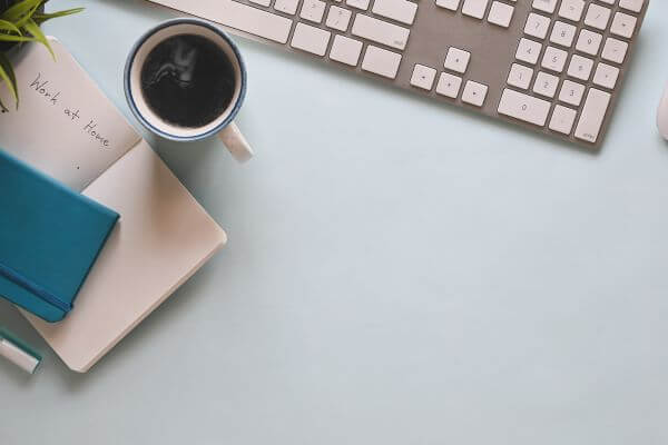 Picture of a keyboard and planner with the words work at home job.