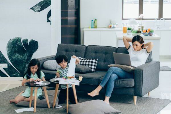 Picture of a woman blogging while watching her kids.