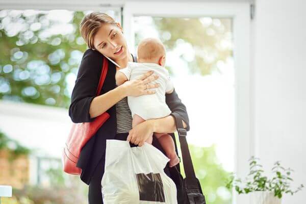 Picture of a mom working and carrying a baby.