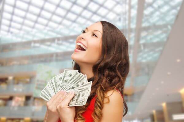 Picture of an excited lady at Christmas with lots of money.