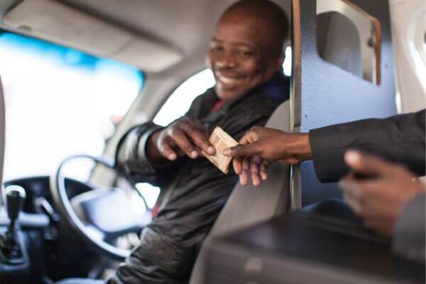 An image of a driver receives money as a fare in exchange of the ride. 