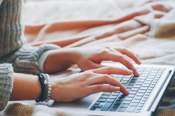 Image of a woman hand typing in a keyboard laptop working on something.