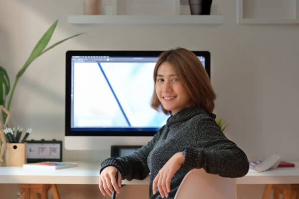 The picture of a girl working on a computer, might probably a work from home set up.