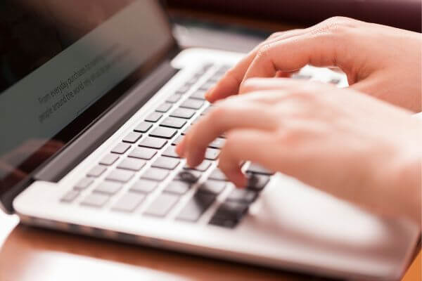 Image of a transcriptionist working on a project using a laptop.