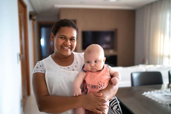 Image of a nanny carrying a baby.