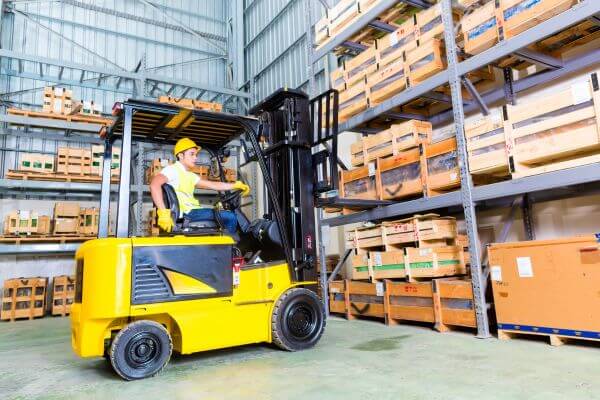 Picture of the man in a four-clip machine lifting and transferring the pallets and boxes. 