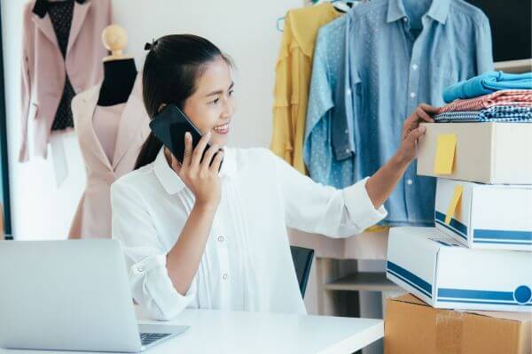 Image of a mother answering her phone while looking at the stuff around her.